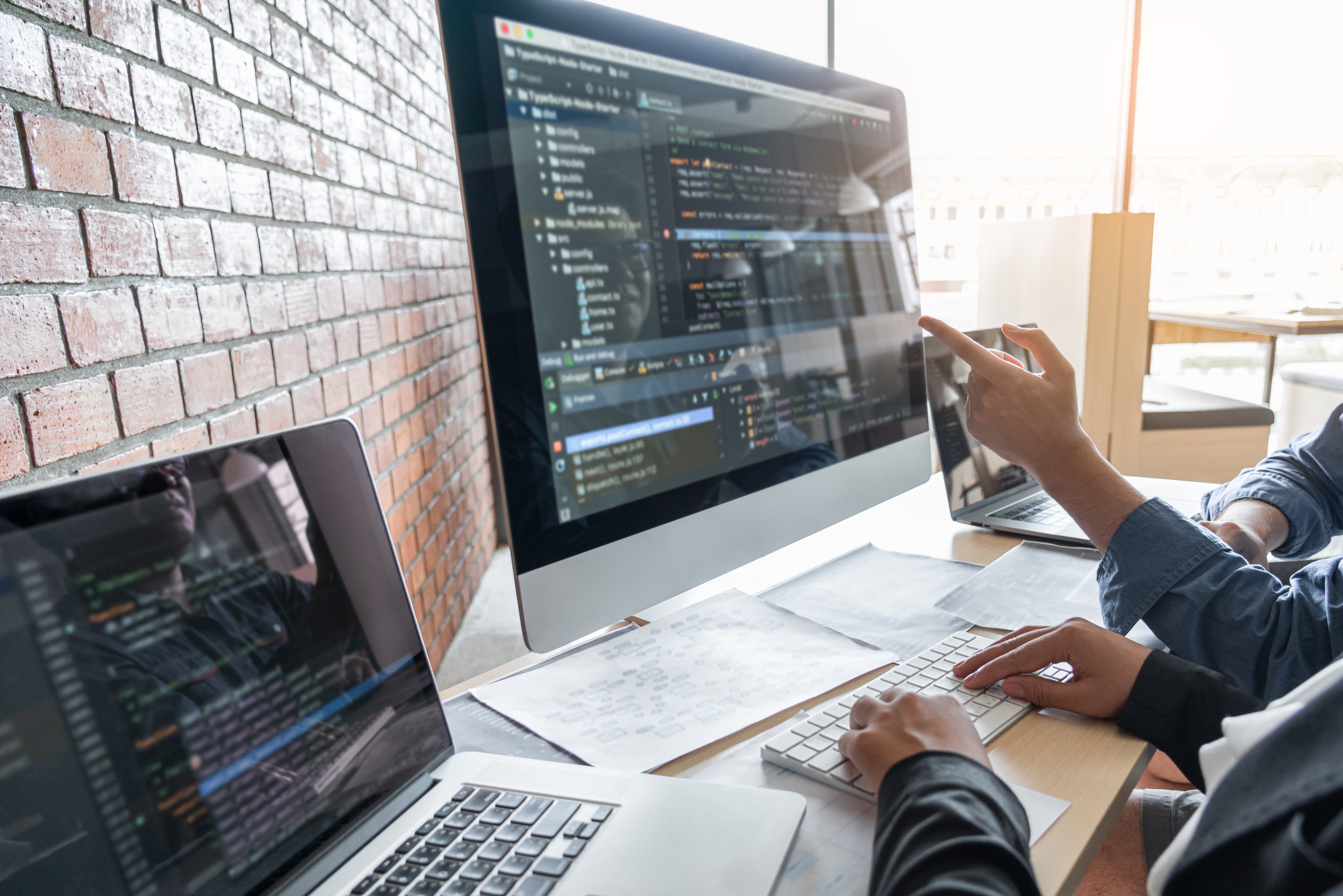 Two professional programmer cooperating and working on web site project in a software developing on desktop computer at company, codes and typing data code, Programming with HTML, PHP and javascript.